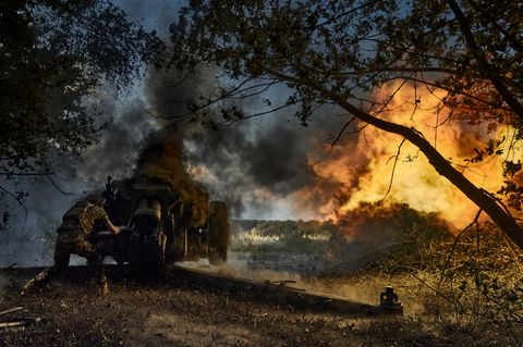 Ein Soldat feuert eine D-30-Kanone auf russische Stellungen an der Frontlinie ab
