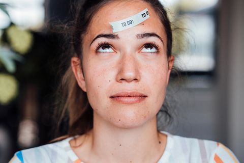 Gehirn: Frau mit To Do Zettel auf der Stirn