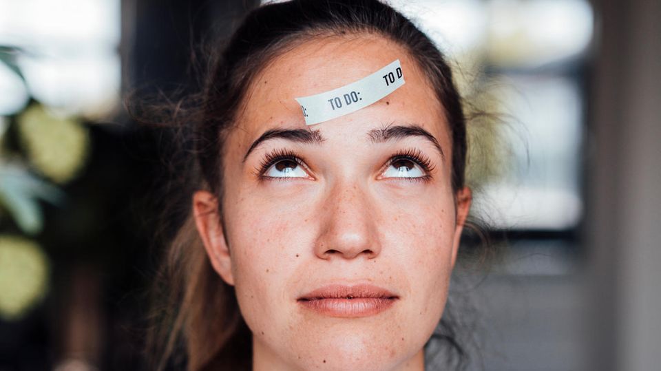 Gehirn: Frau mit To Do Zettel auf der Stirn