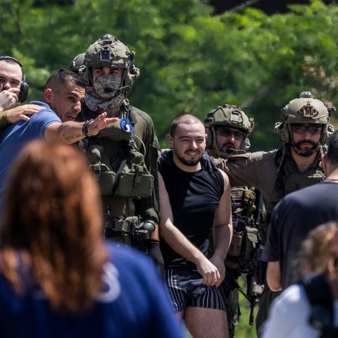 Almog Meir (C), 21, kommt von Soldaten begleitet in Israel an. Er lächelt.