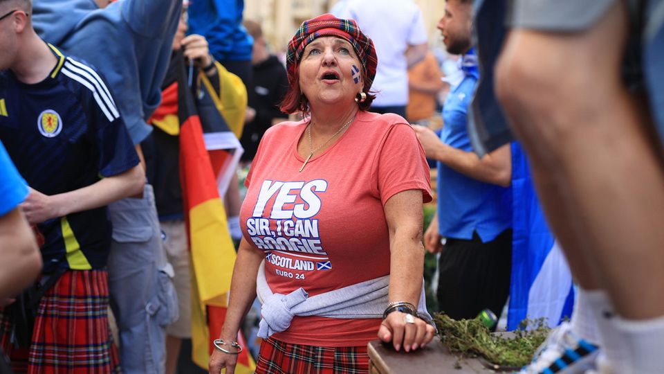 Gut gelaunte Frau unter anderen schottischen Fußballfans