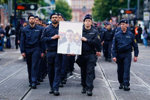 Beim Trauermarsch der Beamten tragen Polizisten das Bild ihres getöteten Kollegen ganz vorne