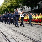 Rettungskräfte stehen in der Innenstadt von Mannheim Spalier, während der Trauerzug der Polizisten an ihnen vorbeizieht