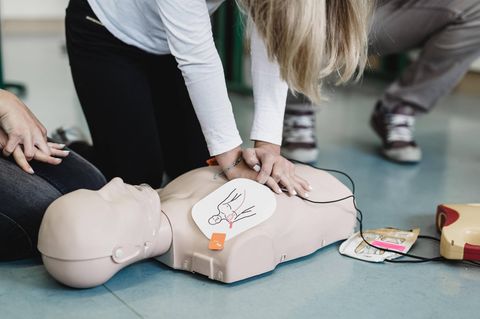 Schülerin übt Herz-Druck-Massage nach einem Herzstillstand