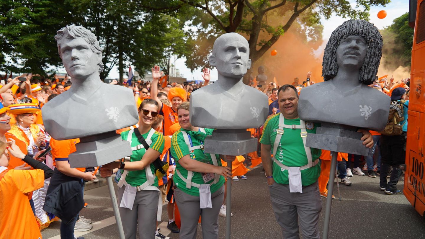 Drei Fans tragen drei niederländische Fußballlegenden beim Fanmarsch durch Hamburg. In der Mitte sieht man Arjen Robben und die rechte Büste soll Ruud Dil Gullit, ehemaliger Mannschaftskapitän der Nationalmannschaft von 1988, darstellen. 