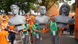 Drei Fans tragen drei niederländische Fußballlegenden beim Fanmarsch durch Hamburg. In der Mitte sieht man Arjen Robben und die rechte Büste soll Ruud Dil Gullit, ehemaliger Mannschaftskapitän der Nationalmannschaft von 1988, darstellen. 