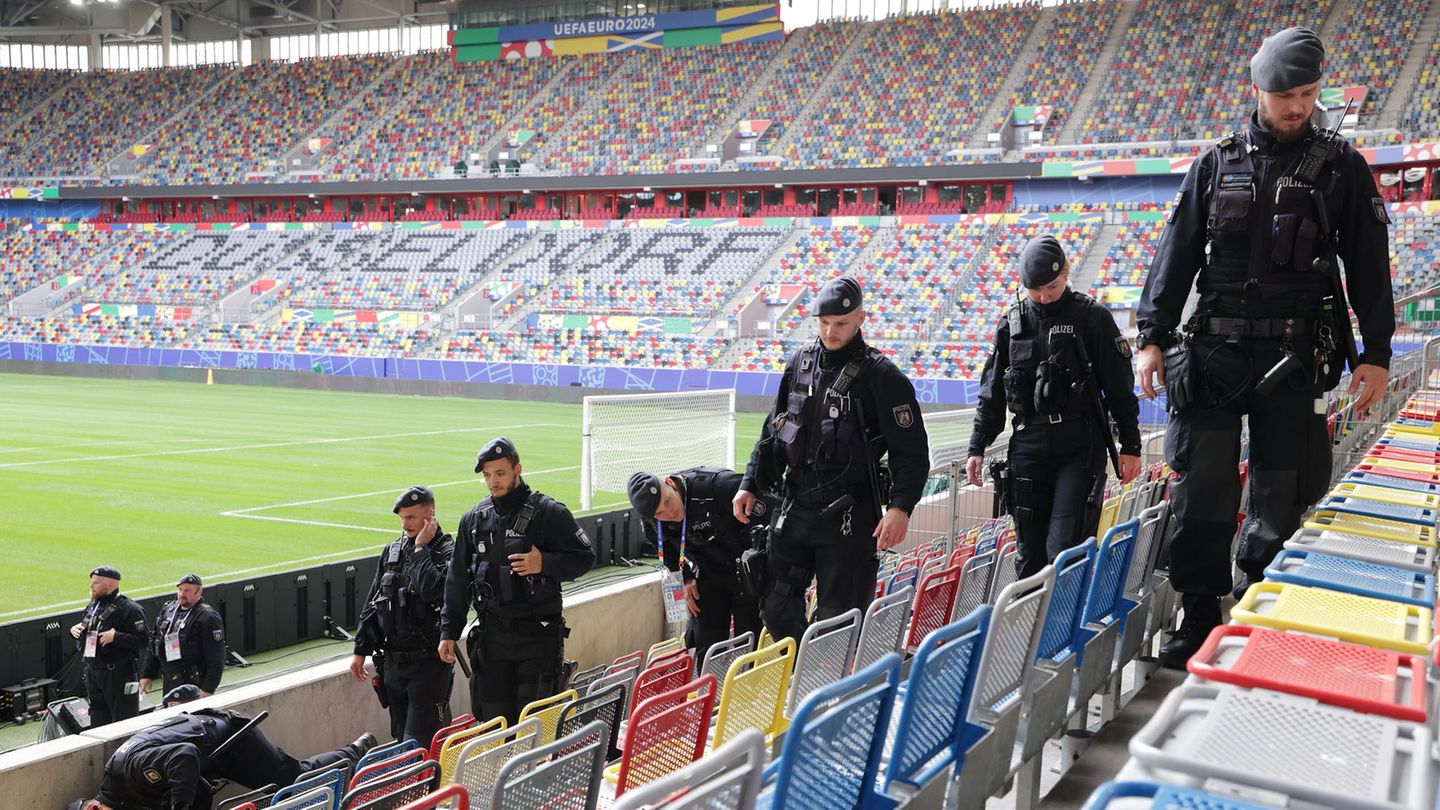 Polizisten schreiten in Düsseldorf die Sitzreihen des Stadions vor der Fußball-EM 2024 ab