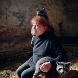 Waschbären spielen und klettern auf dem Rücken der Gründerin des Vereins