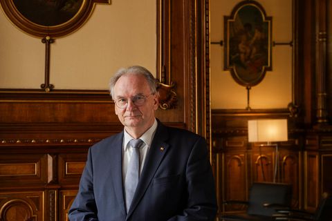 Deutschlands dienstältester Ministerpräsident: Reiner Haseloff steht im Anzug vor einer Holz vertäfelten Wand