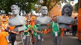 niederländische Fußballfans halten Büsten hoch, während sie durch Hamburgs Straßen ziehen