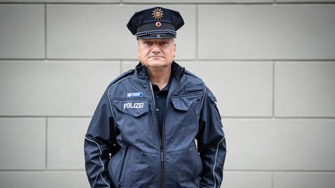 Peter Neumann, 58 Jahre alt, Polizist in der Bereitschaftspolizei Potsdam, steht in Uniform vor einer Hauswand