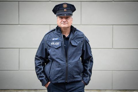 Peter Neumann, 58 Jahre alt, Polizist in der Bereitschaftspolizei Potsdam, steht in Uniform vor einer Hauswand
