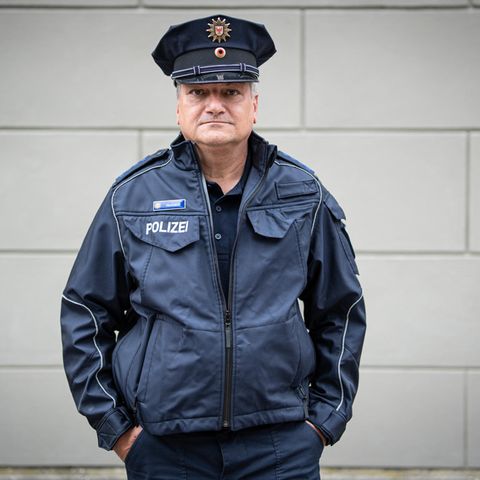 Peter Neumann, 58 Jahre alt, Polizist in der Bereitschaftspolizei Potsdam, steht in Uniform vor einer Hauswand