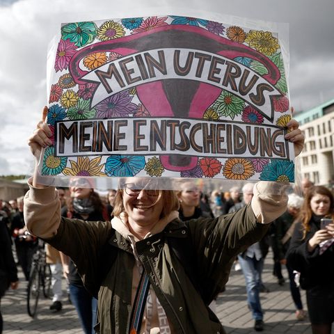 Eine Frau hält ein Poster in der Kamera auf einer Demo auf einer Demo 