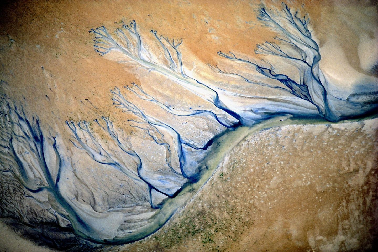 Wie adern zieht sich ein blauer Fluss durch den Sand