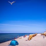 Am Strand von Timmendorf in Mecklenburg-Vorpommern deutet Dienstag vorerst nichts auf drohende Unwetter hin. Doch in einem breiten Streifen vom Westen über die Mitte bis in den Osten können im Laufe des Tages schwere Gewitter auftreten