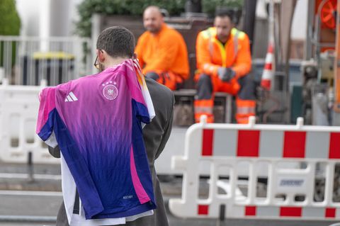 Ein Mann mit den neuen offiziellen EM-Trikots des DFB-Teams