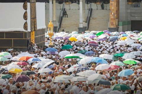 Menschen schützen sich während des Hadsch in Mekka mit Schirmen gegen Sonne und Hitze