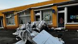 Beschädigte Teile vom Hausdach liegen auf der Straße