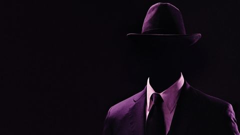 Ein Mann im Anzug, lila eingefärbt, das Gesicht ist nicht sichtbar