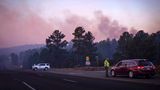 Der Rauch des South Fork Fire spiegelt bei Sonnenaufgang einen rosafarbenen Farbton wider, als Polizisten Autofahrer auf der State Road 48 an der State 220 wegen der Waldbrände in der Nähe von Ruidoso, New Mexico, anhalten