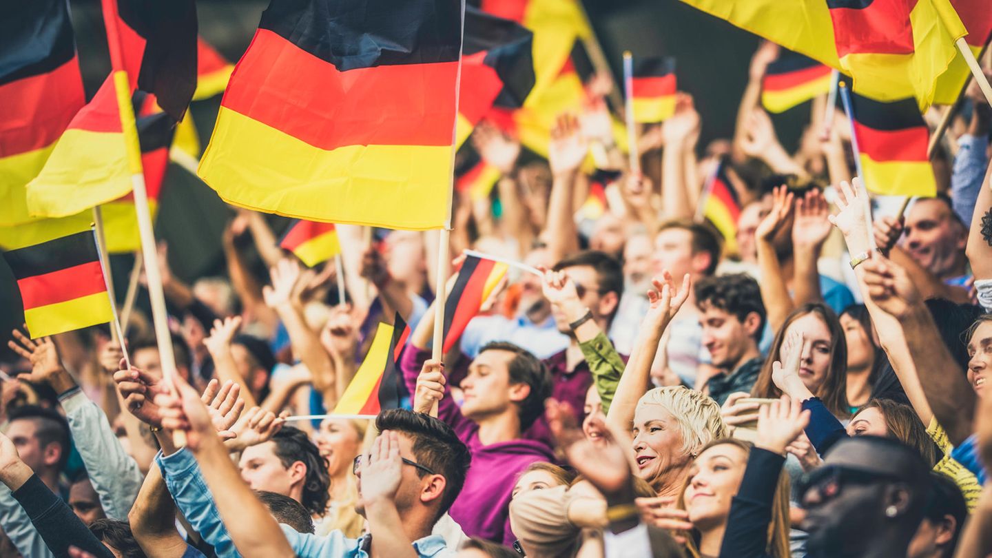 Bild zeigt Fußballfans, die  Deutschlandfahnen schwenken