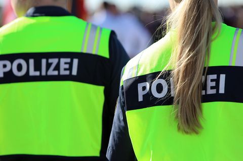 Ein Polizist und eine Polizistin stehen am Flughafen München nebeneinander