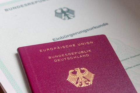 Dokumente der Staatsbürgerschaft: Einbürgerungsurkunde und Reisepass liegen auf einem Tisch