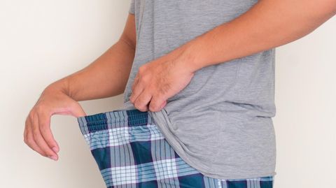 Mann blickt in seine Hose, wird aber wohl kein Mikroplastik sehen können