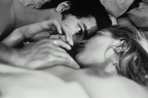 Eine Frau und ein Mann im Bett, die sich mit Leidenschaft anschauen (schwarz-weiß)