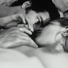 Eine Frau und ein Mann im Bett, die sich mit Leidenschaft anschauen (schwarz-weiß)