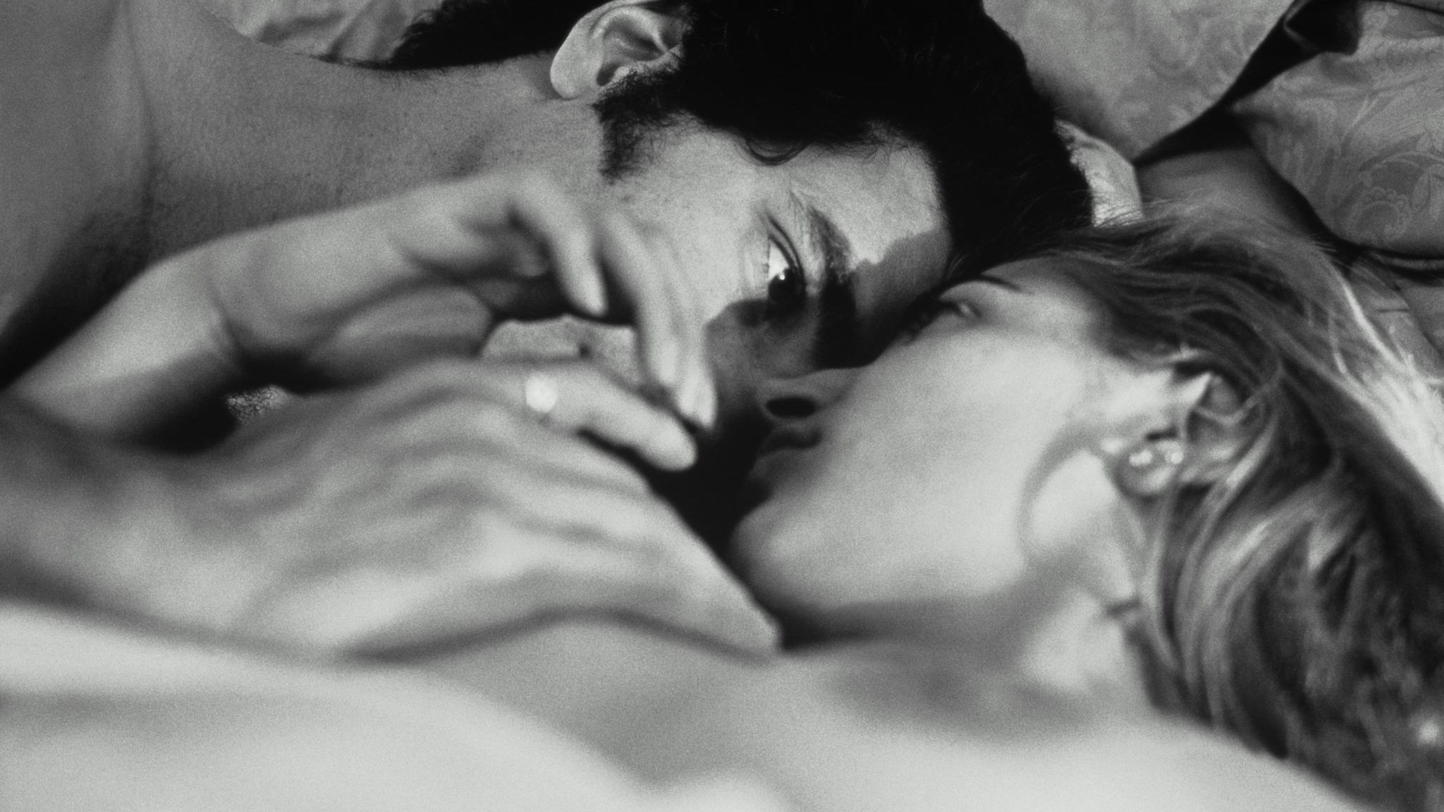 Eine Frau und ein Mann im Bett, die sich mit Leidenschaft anschauen (schwarz-weiß)