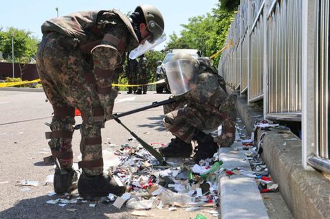 Südkoreanische Soldaten in Schutzkleidung überprüfen Müll eines vermutlich aus Nordkorea entsandten Ballons