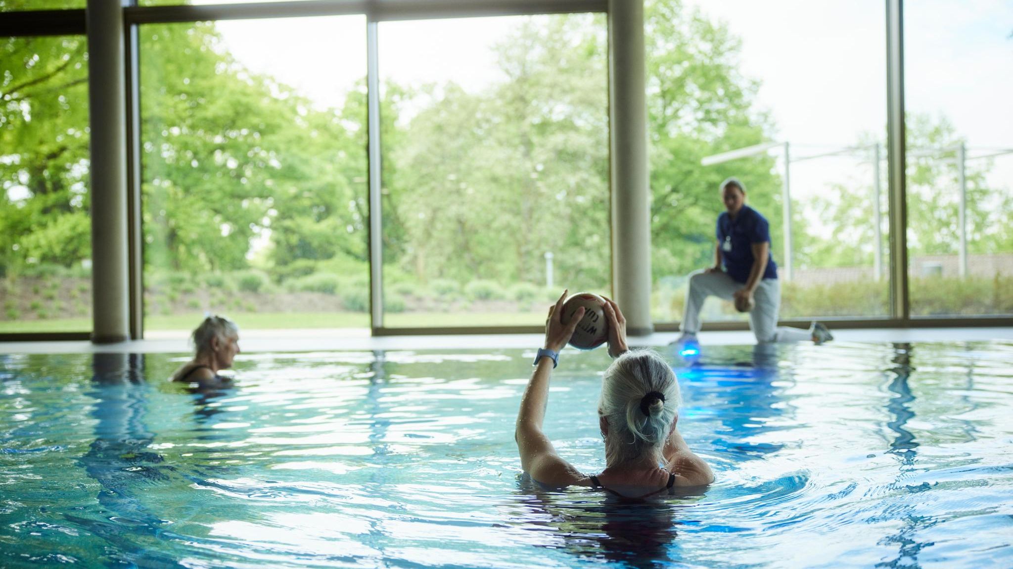 Drei Frauen machen Wassergymnastik im Schwimmbad der Rehaklinik