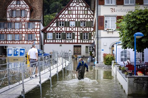 Menschen waten in Berlingen, im schweizer Kanton Thurgau, durch die Fluten
