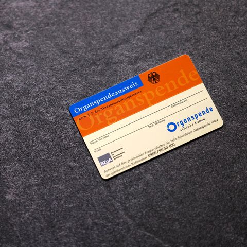 An organ donation card lies on a dark background