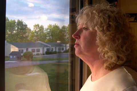 Eine einsame Frau sieht aus dem Fenster