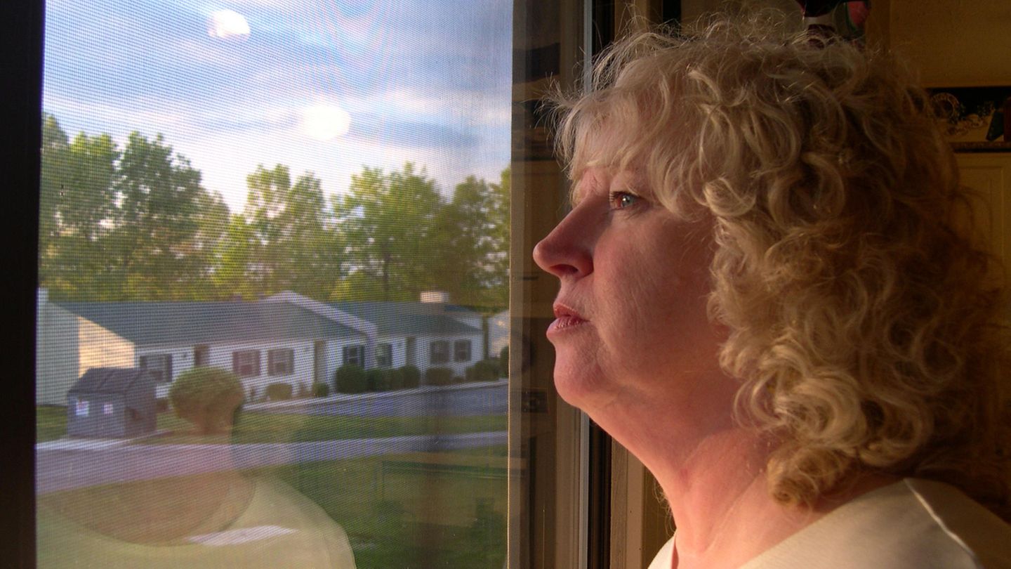 Eine einsame Frau sieht aus dem Fenster