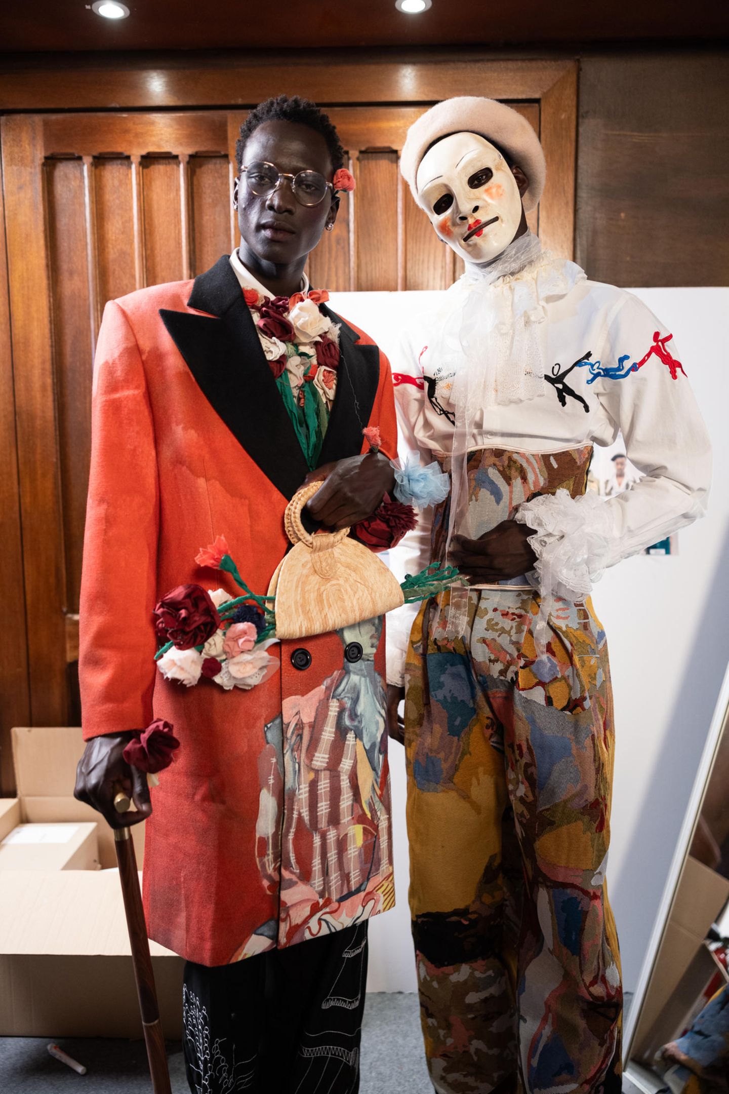Models in Clownskostümen präsentieren Männermode in Paris