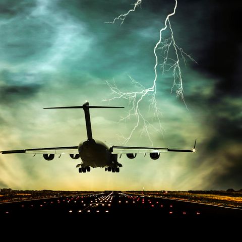 Ein Flugzeug steuert im Gewitter eine Landebahn an