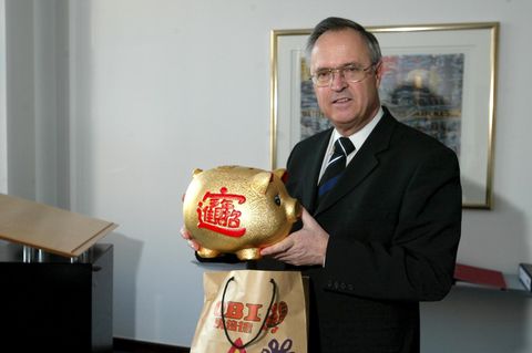 Der ehemalige Bundesfinanzminister Hans Eichel hält in seinem Büro ein großes Sparschwein in der Hand