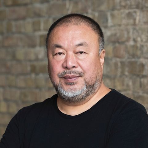 Künstler Ai Weiwei in einem schwarzen T-Shirt vor einer Backsteinwand