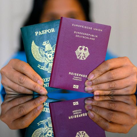 Eine Frau hält einen indonesischen und einen deutschen Pass.
