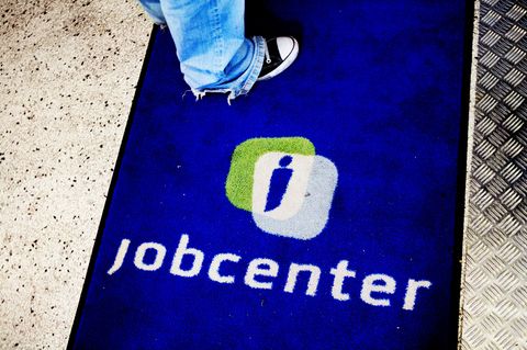 Eine Person steht auf einer Fußmatte mit der Aufschrift Jobcenter