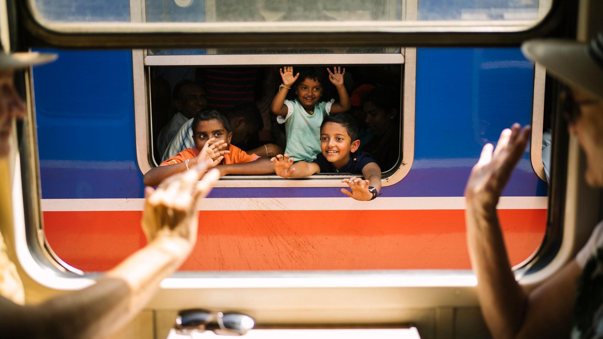 Sri Lanka: Kinder winken aus einem Zugfenster