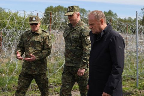 Polens Ministerpräsident Donald Tusk (r-l) zusammen mit Befehlshabern des Grenzschutzes am Zaun zu Belarus