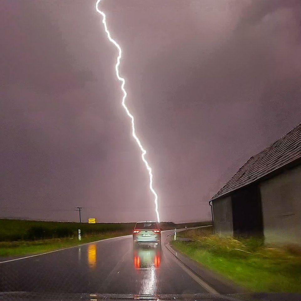 Pförring, Deutschland. Ein Blitz zieht sich wie ein Riss über eine grau-lila Wolkendecke. Im mehreren Teilen des Landes werden heute Gewitter und Unwetter erwartet. In Bayern ging es am frühen Morgen bereits los