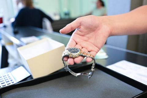 Ein Pfandleiher nimmt eine Luxus-Uhr entgegen