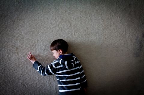 Völlig versunken fährt Jasper mit seinen Fingern die linien einer Teppichwand in der Rehaklinik nach