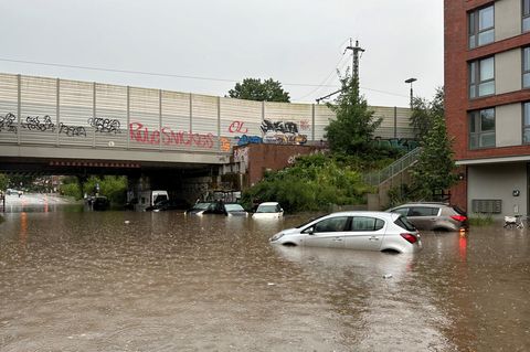 Mehrere Autos stehen bei Regen in einer überfluteten Straße der Unterführung Alte Wöhr im Stadtteil Barmbek-Nord in Hamburg